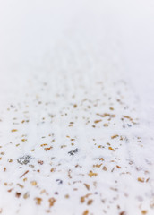 Closeup of colorful stones on sidewalk covered in snow