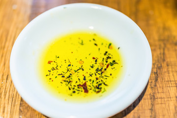 Flat top view of herbed olive oil in small white plate