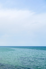 Obraz premium Niebieska falująca woda morska pod pochmurnym niebem. Skopiuj miejsce.