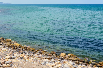                         Stone beach of mediterranean sea in daytime. Natural background.     