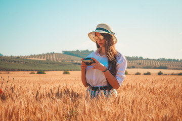 A young girl with a vintage photo camera in a warm landscape