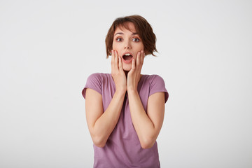 Portrait of happy amazed young attractive girl in with a surprised expression on her face, standing...