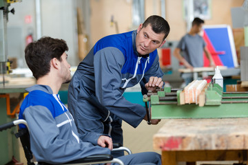 Obraz premium two engineers one in wheelchair working toegther