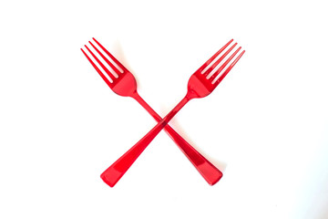Crossed  disposable plastic red forks isolated on white background. Ecology problem. No plastic...