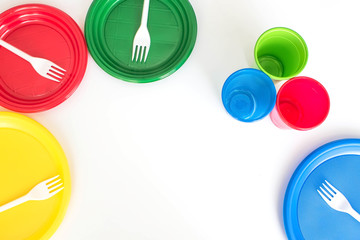 Bright color disposable plastic tableware isolated on white background. Ecology problem.  Top view. Free space for text.