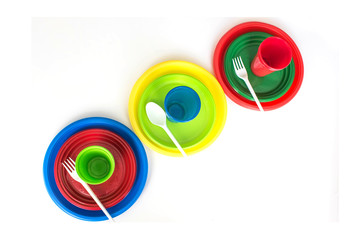 Obraz premium Bright color disposable plastic tableware isolated on white background. Ecology problem. Top view.