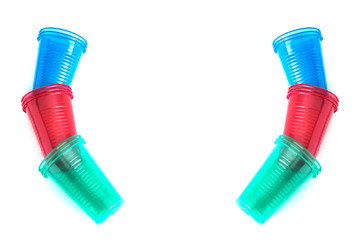 Bright colourful disposable plastic cups isolated on white. Ecology problem. Background and free space for design or text, top view.
