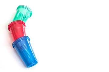 Bright colourful disposable plastic cups isolated on white.  Ecology problem.  Background and free space for design or text, top view.