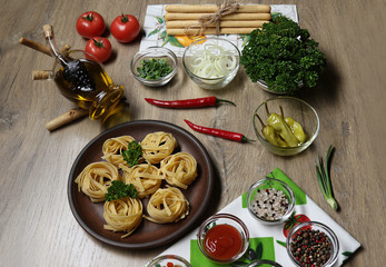 flat lay, top view on the ingredients for cooking pasta on the background of a wooden table , bread sticks, gressini