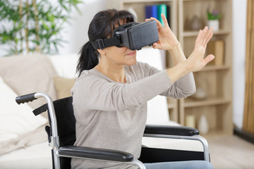 woman in wheelchair using virtual reality glasses