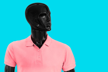 Black Mannequin Dressed Pink Polo Shirt Against Blue Background. Concept Summer Beach Relaxation. Isolated Mannequin For Copy Space.