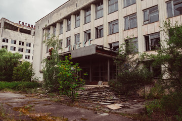 Fototapeta na wymiar Chernobyl Exclusion Zone, Ukraine. Destroyed abandoned ghost city Pripyat ruins after disaster. Nuclear Power Plant atomic reactor sign. Lost town. Text translation: hotel complex.