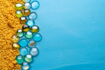 coarse sand with transparent stones on the background of blue clear water. summer concept. imitation of the beach