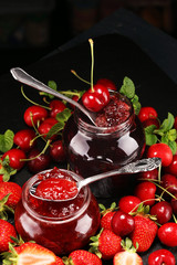assortment of jams, seasonal berries, mint and fruits. marmalade or confiture