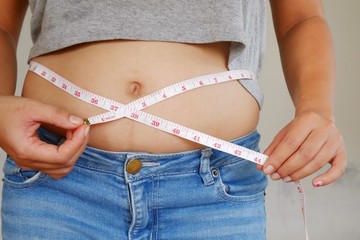 Fat Woman measures her waist. Overweight belly and abdomen. Healthy care concept.