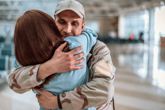 Happy young couple hugging each other in big hall