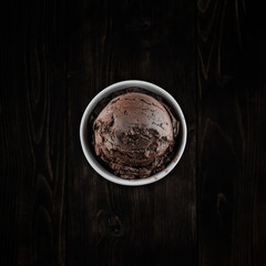Chocolate ice cream with bowl on wooden background