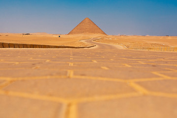Fototapeta na wymiar Lone road leading towards a pyramid Egypt 