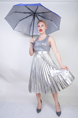 cute chubby short hair girl in a modern city metallic silver dress holding an umbrella and posing on a white background in the Studio alone