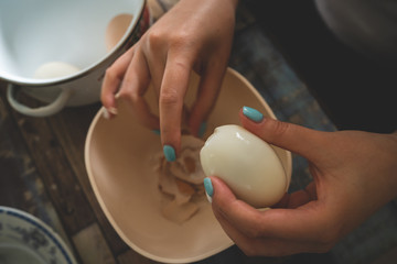 High angle view on female hands woman girl pealing boiled egg at home domestic farm natural organic food