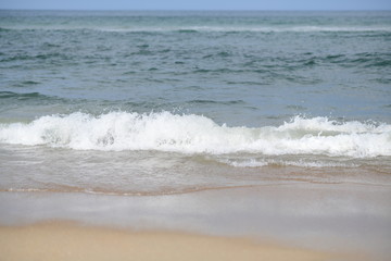 closeup on waves hitting the beach on a sunny summer day