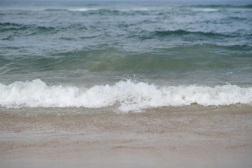Fototapeta na wymiar closeup on waves hitting the beach on a sunny summer day