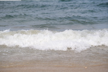 closeup on waves hitting the beach on a sunny summer day