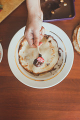 A little boy with his mother preparing together a breakfast. Mother and son smearing chocolate cream to thin pancakes. Free space