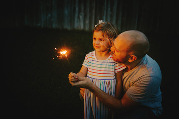 Father and Daughter doing firework sparklers together
