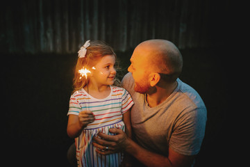 Father and Daughter doing firework sparklers together