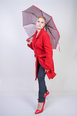 cute short hair chubby girl in a modern city wool coat holding a red umbrella and posing on a white background in the Studio alone