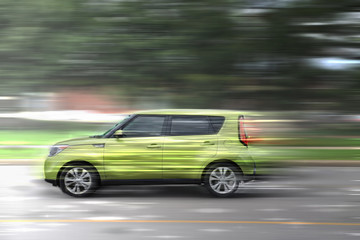 Plakat A green car at high speed rides along the road, speed in motion