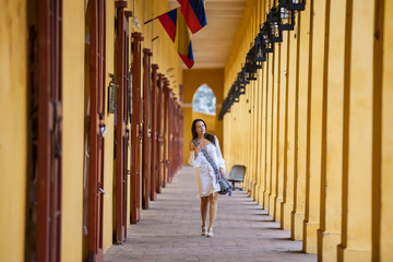 Beautiful woman walking around the walled city in Cartagena de Indias - obrazy, fototapety, plakaty