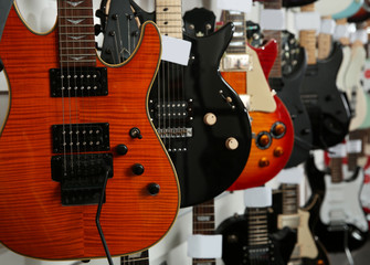 Obraz na płótnie Canvas Row of different guitars in music store, closeup