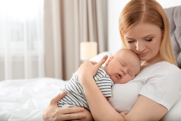Fototapeta na wymiar Mother with her sleeping baby in bedroom
