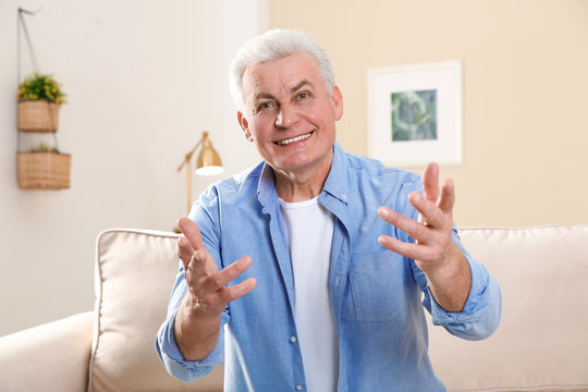 Mature Man Using Video Chat At Home, View From Web Camera