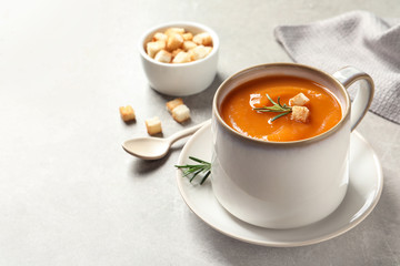 Mug of tasty sweet potato soup served on table. Space for text