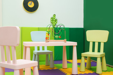 Stylish playroom interior with table and chairs