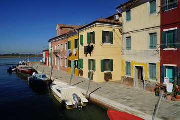 Fototapeta na wymiar Canal and sidewalk of Burano Island, Venice, Italy