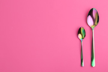 Clean spoons and space for text on color background, flat lay