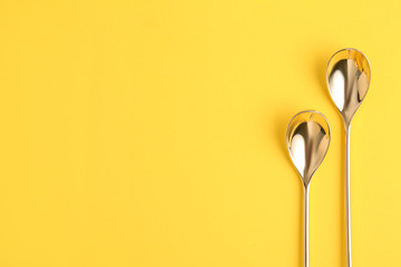 Clean tea spoons and space for text on color background, flat lay