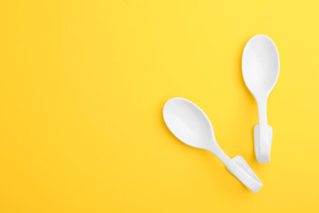 Clean ceramic appetizer spoons and space for text on color background, flat lay