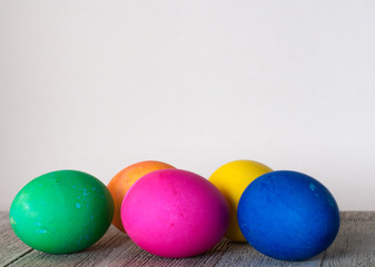 Fototapeta na wymiar row of 5 easter eggs on wooden light wood with white background