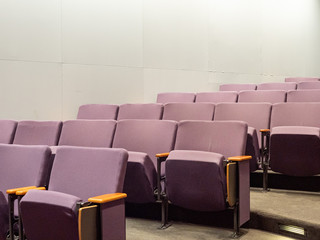 Purple theater style chairs in empty clean small auditorium