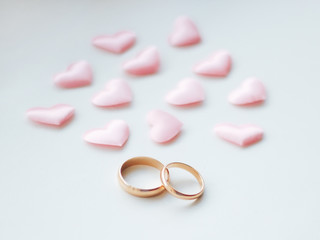 Wedding rings on a white background in pink hearts