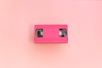 Pink video cassette tape on pink background.