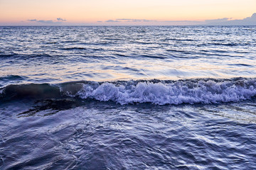 The silky ocean of Hawaii during sunset with waves breaking down on the beach of Maui.