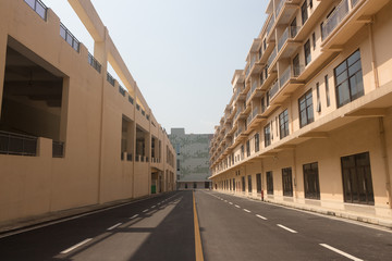 Nobody's town block tarmac road with yellow modern buildings on both sides