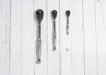 Tools, socket wrenches on a white wooden background