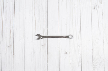 Tools, wrench on a white wooden background